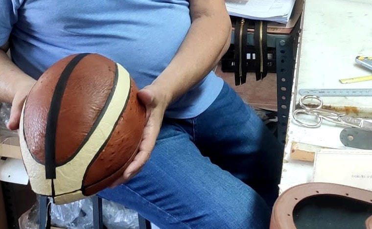 Artesano trabajando sobre un balón durante la fabricación de un bolso
